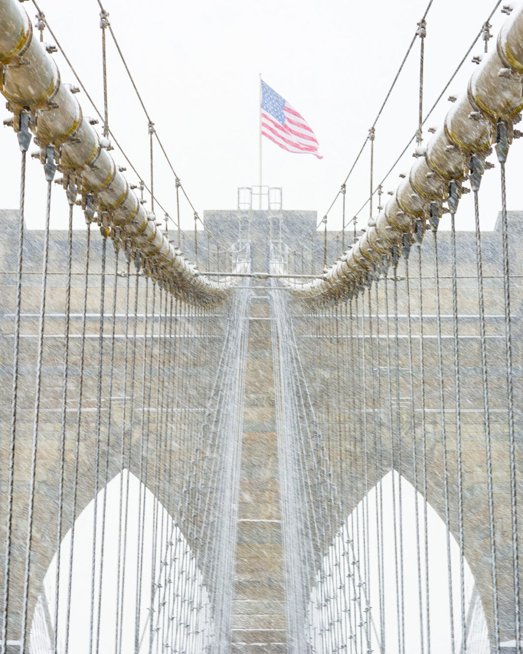 Brooklyn Bridge and flag in snowstorm